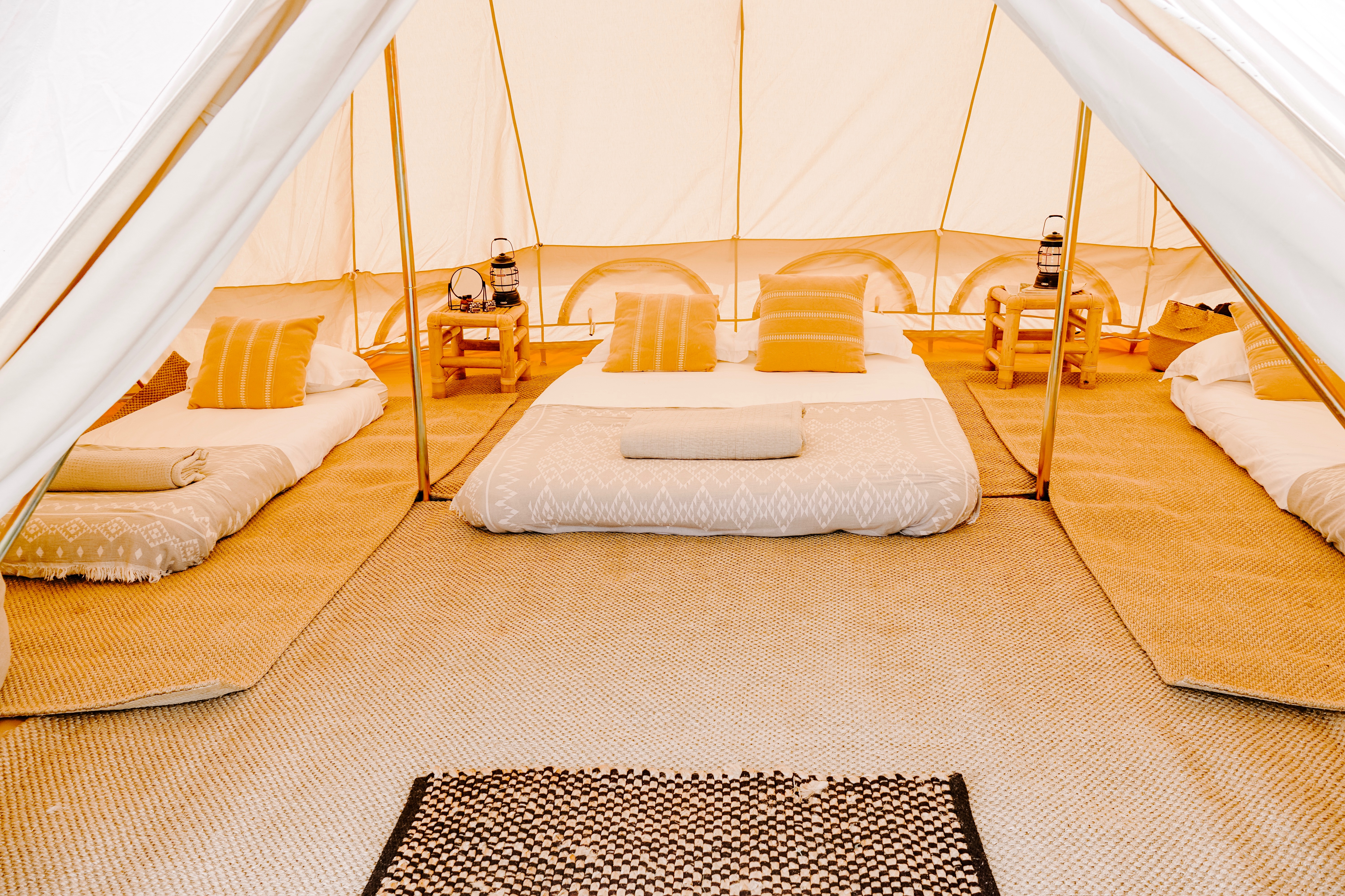 inside of Emperor bell tent featuring queen bed and 2 singles